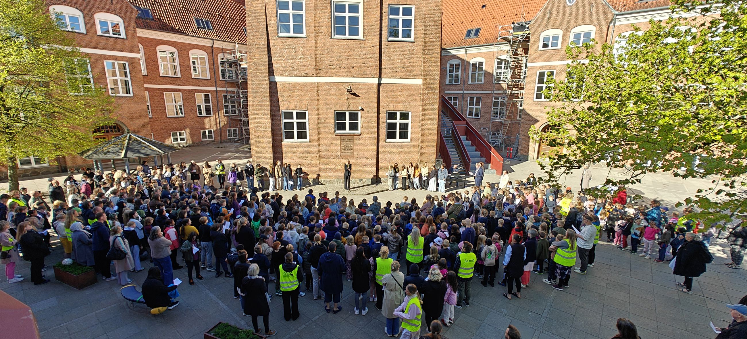 Børnene er samlet foran mindepladen på Hobrovejens Skole